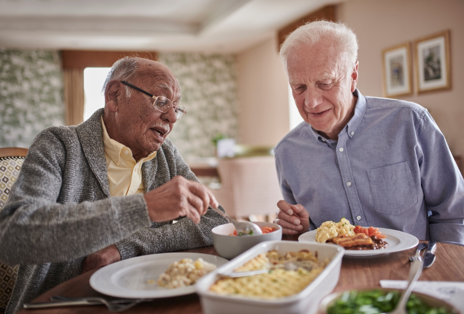 Two older gentlemen take their pick of food